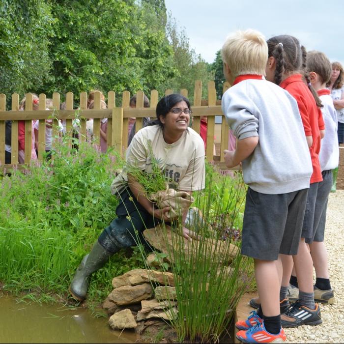 Adult showing children about gardening